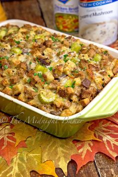 a casserole dish with stuffing and vegetables in it on a table next to other food