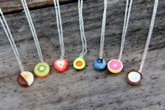 fruit necklaces are displayed on a wooden surface