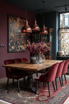 a dining room table surrounded by red chairs