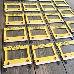 rows of yellow and white license plates with red pins on them sitting on a wooden floor