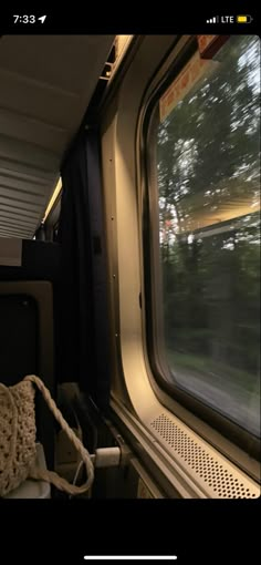 an empty train car with the window open and trees in the backgrouund