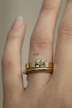 a close up of a person's hand with a ring on their finger and a diamond in the middle