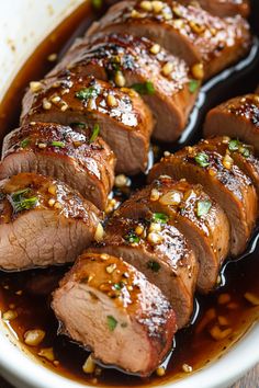 sliced meat with sauce and garnish in a white bowl