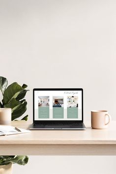 an open laptop computer sitting on top of a wooden desk next to a cup and plant