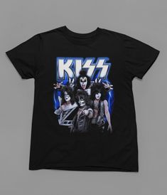 Immerse yourself in the legendary energy of KISS with this epic Rock Music T-Shirt! Welcome to Poster Kingz, your ultimate destination for T-shirt enthusiasts and pop culture aficionados! We take immense pride in curating a captivating collection of T-shirts inspired by your favorite films, beloved TV shows, and iconic music artists. Quality and Comfort:Our T-shirts are crafted with the utmost care, using premium materials to ensure comfort and durability. Made from soft, breathable fabric, these tees are perfect for everyday wear or as a statement piece to showcase your passion for pop culture. Film, TV, and Music Delights:Indulge in nostalgia and relive memorable moments with our diverse range of T-shirts. From classic movie quotes to iconic TV show references, and legendary music band a Kiss Band T Shirt, Unisex Rock And Roll T-shirt For Streetwear, Pop Culture Graphic Print T-shirt For Concert, Rock And Roll Band Logo T-shirt For Fans, Band Merch T-shirt With Graphic Print For Fans, Band Merch T-shirt With Sublimation Print, Band Merch Graphic Print T-shirt For Fans, Rock And Roll Band Logo T-shirt For Music Festivals, Rock And Roll Band Logo T-shirt For Streetwear