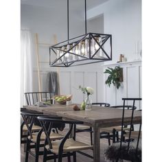 a dining room table with chairs and a chandelier hanging over it's head