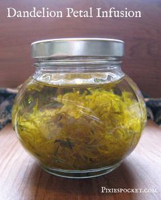 a glass jar filled with yellow flowers on top of a wooden table