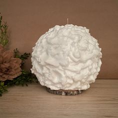 a white candle sitting on top of a wooden table