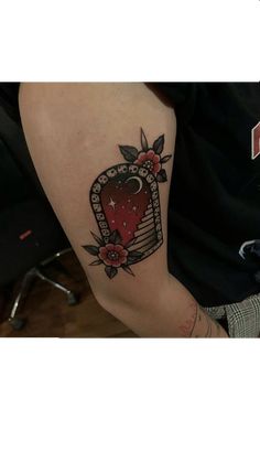 a tattoo on the arm of a person with a strawberry in an open book and stars