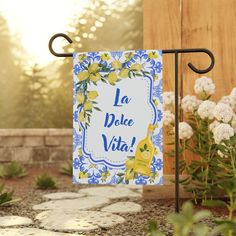 a sign that says la dolce vita with flowers in the background