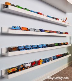 there are three shelves with toy trains on them