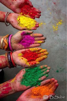 several hands with different colored powder on them