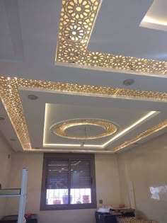 the ceiling in this room is decorated with gold and white tiles, along with decorative lights