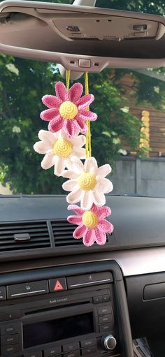 a car dashboard with flowers hanging from it's dash board