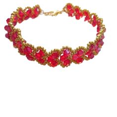 a bracelet with red beads and gold chains on it's sides, sitting against a white background