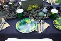 the table is set with camouflage plates and silverware