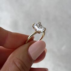 a person holding a ring with a diamond in it's middle and one hand