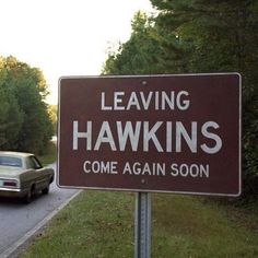 a sign that says leaving hawks come again soon next to a car on the road