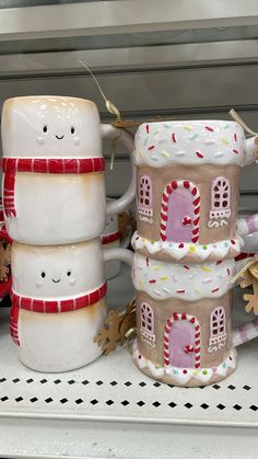 three ceramic mugs are stacked on top of each other in the shape of gingerbread houses