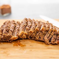 sliced up meat sitting on top of a wooden cutting board