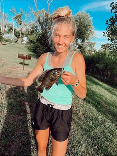 a woman holding a small fish in her hands