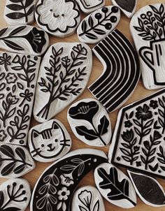 some black and white decorated cookies sitting on top of a wooden table next to each other