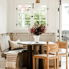 a table with two chairs and a vase on it