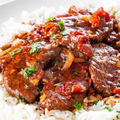 a white plate topped with rice and meat covered in gravy on top of it