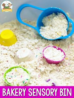 a bowl filled with white rice next to two blue scoops and a yellow cup