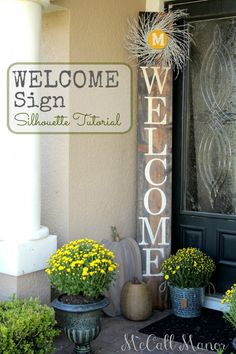 a welcome sign on the front door of a house with potted plants and pumpkins