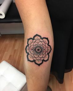 a woman's leg with a tattoo on it that has a black and white flower