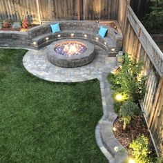 an outdoor fire pit surrounded by green grass