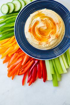 hummus with carrots, celery and cucumbers on a plate