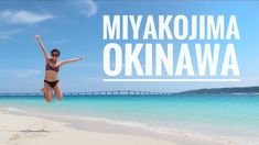 a woman jumping into the air on top of a beach