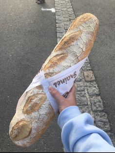 a person holding a long loaf of bread