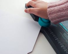 a person's hand on top of a piece of paper