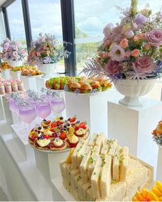 an assortment of desserts and pastries on display in front of large glass windows