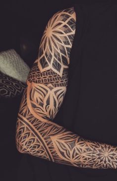 a man's arm with intricate tattoos on it