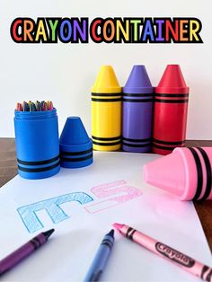 crayon containers and crayons on top of paper with the words crayon container