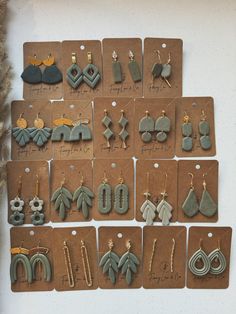 a collection of earrings displayed on brown cards