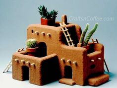 an adobe - style house with cactus and succulents on the roof is made out of clay