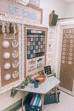 a bulletin board with pictures on it next to a table and chairs in a room