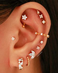 an ear with three different types of piercings on it's sides and two smaller ones