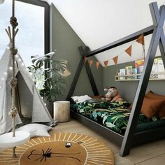 a child's bedroom with a teepee tent, bed and stuffed animals on the floor