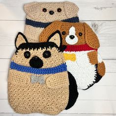 three crocheted dog purses on white wood