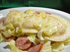 a white plate topped with cabbage and meat