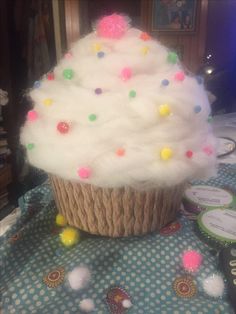 a cupcake with white frosting and multi colored sprinkles