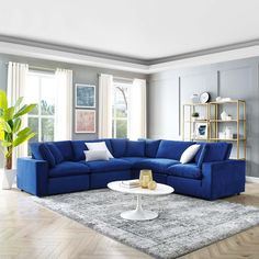 a living room with blue couches and white coffee table in the middle of it