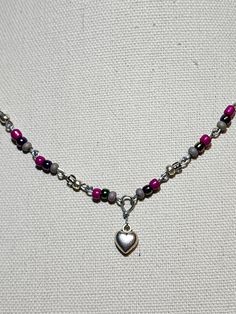 Metal heart charm with pink, gray, & metallic glass accent beads Silver Heart-shaped Beaded Necklaces, Silver Beaded Necklaces For Valentine's Day, Silver Beaded Necklace With Heart Charm, Silver Beaded Heart Necklace, Silver Heart-shaped Adjustable Beaded Necklace, Gray Jewelry With Colorful Beads For Gift, Adjustable Silver Heart-shaped Beaded Necklace, Beaded Silver Heart Necklace, Valentine's Day Silver Beaded Necklace With Heart Beads