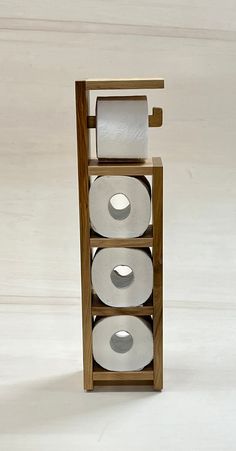 three rolls of toilet paper in a wooden holder